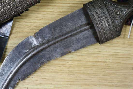 An Omani khanjar in decorative white metal-mounted wooden scabbard on woven belt and two other items,